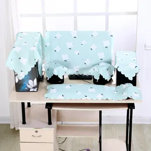 Detailansicht eines minzgrünen Computer-Staubschutz-Sets mit Blumenmuster auf einem Tisch