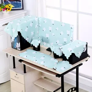 Detailansicht eines hellblauen Computer-Staubschutz-Sets mit Blumenmuster auf einem Schreibtisch