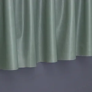 Close-up of sage green pleated dust cover fabric showing smooth texture and vertical drapes.