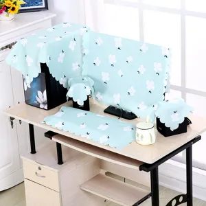 Komplettes Set hellblauer floraler Computer-Staubschutzhüllen auf einem Schreibtisch
