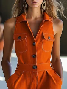 Orange sleeveless lapel front button utility romper detail view showing structural design.