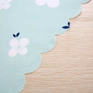 Makroansicht der Wellenkante und des Blumenmusters einer hellblauen Staubschutzhülle.