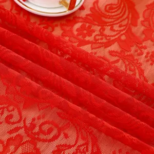 Gros plan détaillé d'une nappe en dentelle rouge brodée aux motifs floraux délicats