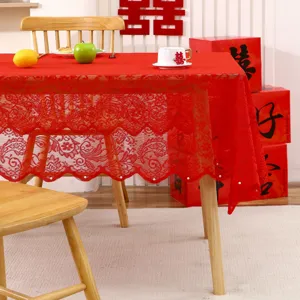 Une vue détaillée d'une nappe en dentelle rouge avec broderie florale et perles fines.