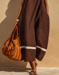 Close-up of a brown linen-blend sleeveless maxi dress with a white striped hem detail