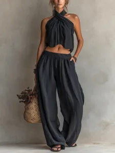 Macro view of black linen-textured cross-halter top and high-waisted wide-leg trousers set