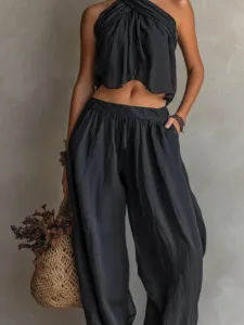 Detail view of a black two-piece set featuring a halter top and loose trousers with pockets.