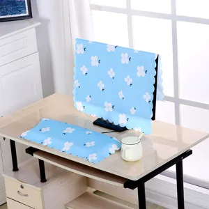Blaues Staubschutz-Set mit Blumenmuster für Monitor und Tastatur auf einem Holzschreibtisch.