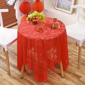 Détail de nappe de mariage en dentelle rouge avec broderie florale et bord perlé