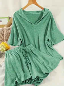 Dettaglio del set per il tempo libero verde con top con cappuccio e pantaloncini abbinati
