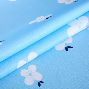 Nahaufnahme eines hellblauen Blumenstoffs für Computer-Staubschutzhüllen mit Webstruktur