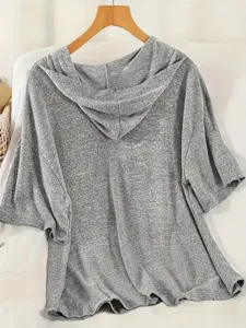 Vista posteriore di un top grigio con cappuccio e maniche corte per set sportivo da donna.