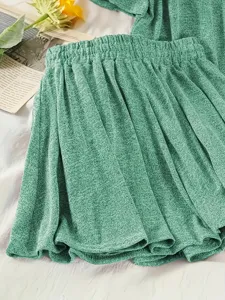 Primo piano del tessuto strutturato verde e della vita elastica su skort casual.