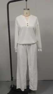 Vista completa di un set bianco con top a maniche lunghe e pantaloni larghi su manichino