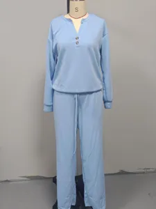 Dettaglio del set azzurro con maglia a maniche lunghe e pantaloni a gamba larga sportivi.