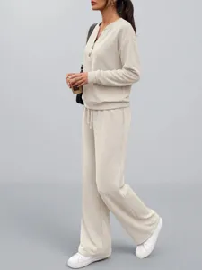 Vista laterale del set beige con top a maniche lunghe e pantaloni a gamba larga