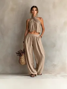 Bohemian beige linen two-piece set featuring halter neck crop top and wide-leg pants