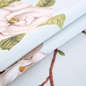 Nahaufnahme des weißen Magnolienmusters auf dem hellblauen Stoff der Computerabdeckung