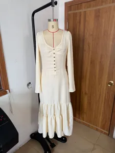 Detailed view of a cream vintage western style maxi dress with buttons and ruffles