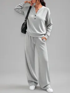 Vista frontale di un set casual grigio a due pezzi con top a bottoni e pantaloni larghi