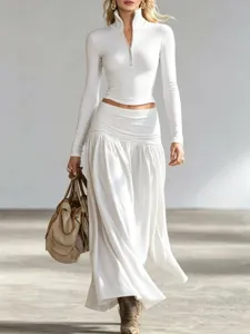 Elegant white long sleeve half-zip top paired with a flowing pleated low-waist maxi skirt set