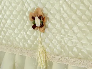 Gesteppte Kühlschrank-Staubabdeckung mit Blumenquaste und Spitzensaum, elegantes Design.