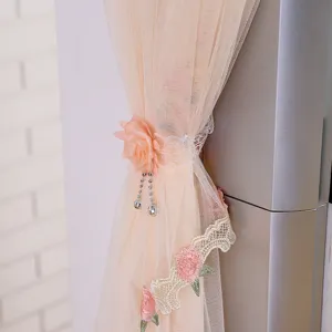 Dettaglio della copertura per condizionatore in tulle pesca con pizzo e rosa