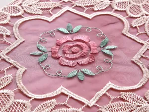 Vista macro dettagliata del ricamo di rose su elegante tovaglia in filato di vetro rosa