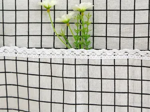 Detalle de la funda antipolvo para refrigerador de cuadros blancos y negros con encaje elegante