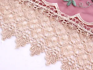 Dettaglio del ricamo floreale elegante e del bordo in pizzo su tovaglia di vetro rosa