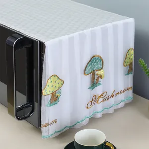Close-up view of delicate mushroom embroidery on white lace microwave dust cover