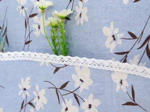 Detalle de la funda antipolvo para refrigerador azul con elegante adorno de encaje blanco