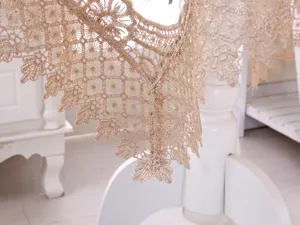 Dettaglio ravvicinato di un'elegante tovaglia ricamata in pizzo champagne con fiori