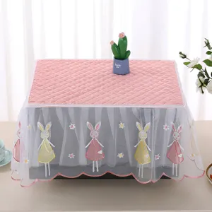 Close-up of pink quilted fabric and lace dust cover with bunny embroidery