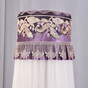 Dettaglio copri condizionatore in pizzo viola con ricami floreali eleganti e frange.
