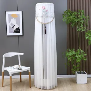 White cylindrical air conditioner dust cover with floral embroidery in a modern home interior