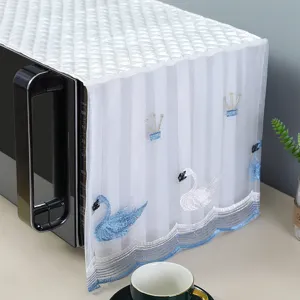 Detailed view of white quilted microwave dust cover featuring elegant swan embroidery