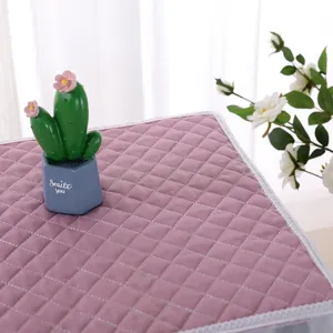 Close-up detail of dusty pink quilted fabric oven cover with white lace trim