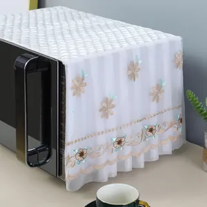 Macro view of white lace microwave dust cover featuring elegant floral embroidery