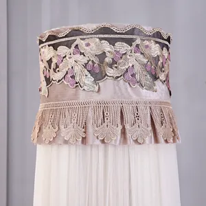 Dettaglio dell'elegante ricamo floreale dorato e delle frange in pizzo per condizionatore