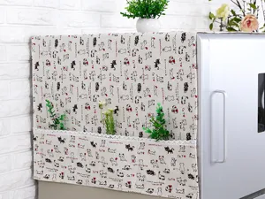 Detalle de la funda antipolvo minimalista para nevera con motivos de gatos y encaje