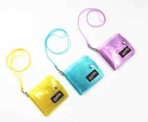 Detailed view of three glittery transparent PVC neck wallets in yellow blue and purple