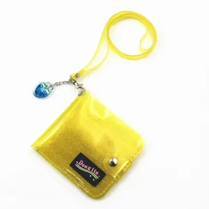 Close-up of a yellow glitter PVC card holder with lanyard and strawberry charm