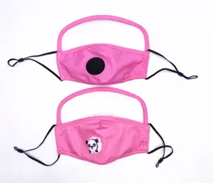 Detalle de dos mascarillas rosas para niños con válvulas de panda y viseras protectoras.