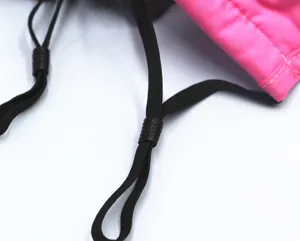 Makro-Detail der verstellbaren schwarzen elastischen Ohrschlaufen einer rosa Baumwollmaske