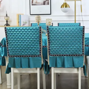 Teal quilted chair back covers with heart patterns and matching ruffled tablecloth detail