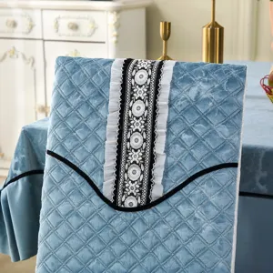 Close-up of blue quilted chair cover with elegant black lace and floral embroidery detail.