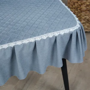 Gros plan d'une housse de chaise bleue matelassée avec dentelle blanche et jupe plissée