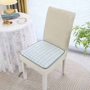 Gros plan d'un coussin de chaise à carreaux verts sur une chaise de salle à manger