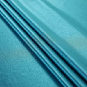 Macro detail of teal satin fabric showing smooth texture and elegant sheen for home decor